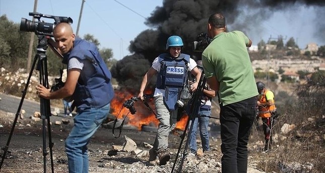 في هذه الصورة غير المؤرخة، يقوم صحفيون فلسطينيون بتغطية هجوم إسرائيلي على موقع في غزة، فلسطين. صورة أأ