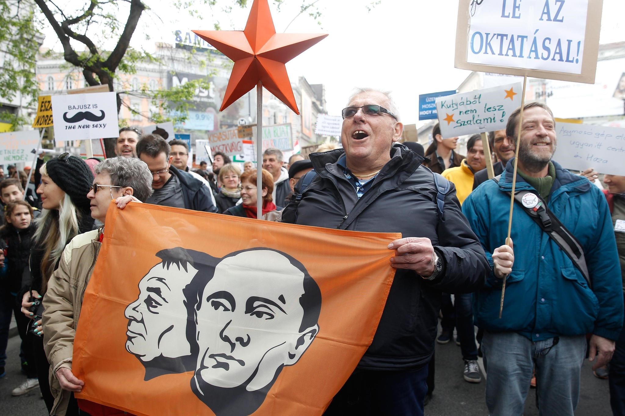 Supporters of the Hungarian satiricial Two-tailed Dog Party are carrying a flag depicting Russian president Vladimir Putin, right, and Hungarian Prime Minister Viktor Orban during their demonstration in Budapest, Sat. April 22, 2017. (AFP Photo)