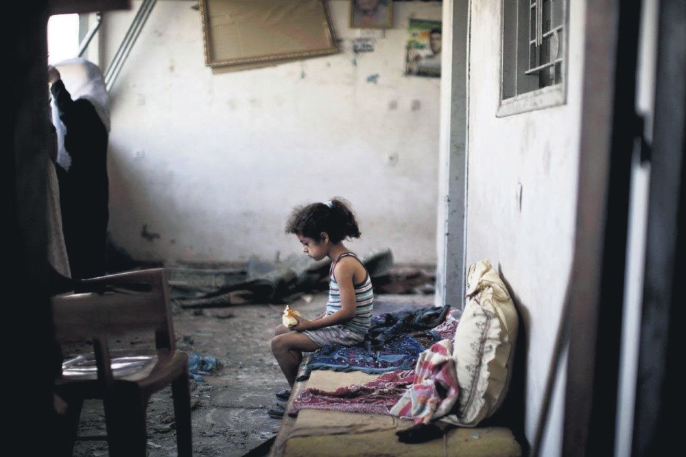 A Palestinian girl sits in the rubble of her destroyed home following an overnight Israeli airstrike on Gaza City, Aug. 2, 2014. 