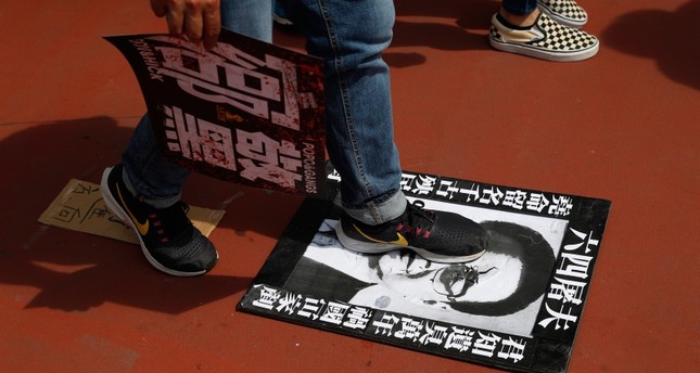 متظاهرون في هونغ كونغ يدوسون صورة رئيس الوزراء الأسبق المسؤول عن مقتل المئات في ساحة تيان أنمين AP