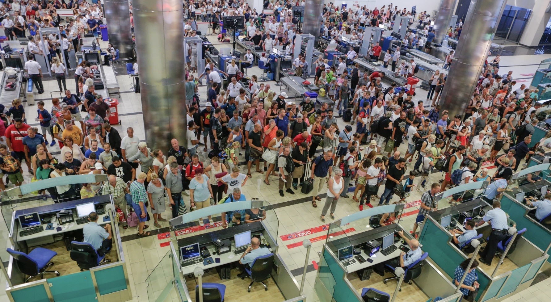 People wait in line for the security and passport control at Antalya International Airport, Turkey on Aug. 10.