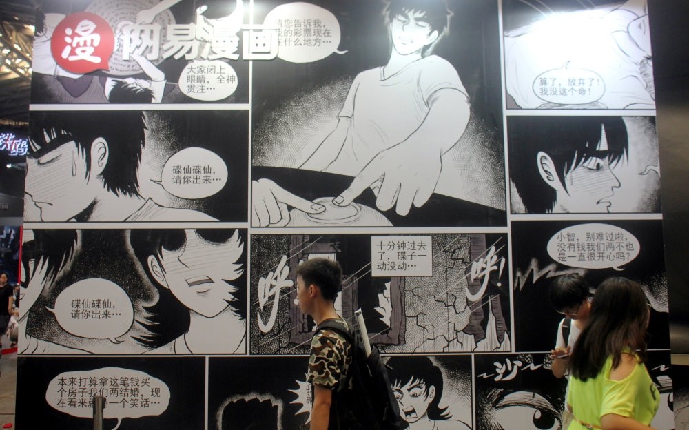 People walk past a booth of NetEase Comics at the China International Cartoon and Game Expo in Shanghai.