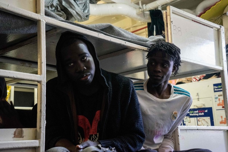 Rescued migrants sit in a closed area normally reserved to women and children, onboard the Dutch-flagged rescue vessel Sea Watch 3 on January 5, 2019, sailing the Mediterranean about 3 nautical miles off Malta's coast (AFP Photo)