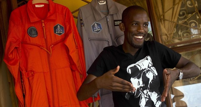 In this file picture taken on Jan. 9, 2014, Mandla Maseko speaks to a journalist in front of two NASA spacesuits in Mabopane, north of Pretoria. (AFP Photo)