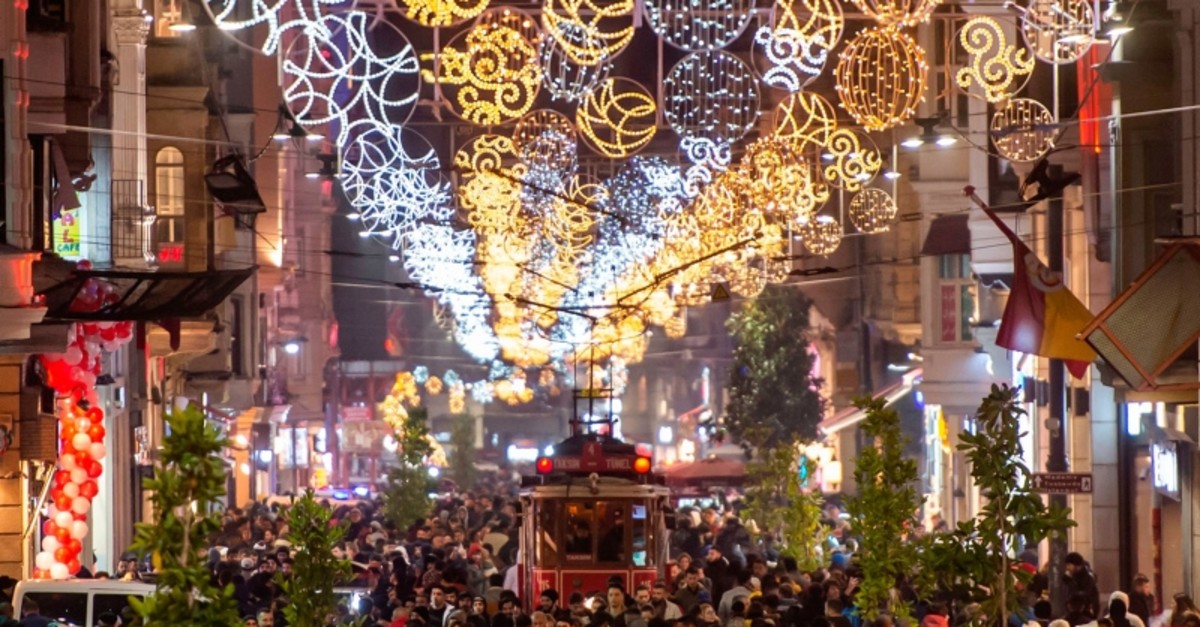 People walk past a historical tramway under Christmas light decorations on Istiklal street during preparations to celebrate the New Year 2020 in Istanbul on December 31, 2019. (AFP Photo)
