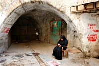 A Palestinian woman sits in the West Bank city of Hebron, May 8, 2017.
