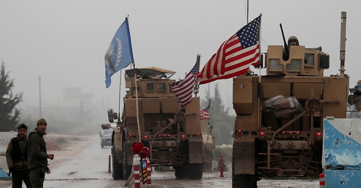 A line of US military vehicles drive through a checkpoint of the Internal Security Forces in Manbij as they head to their base on the outskirts of the northern Syrian city on Dec. 30, 2018 (AFP File Photo)