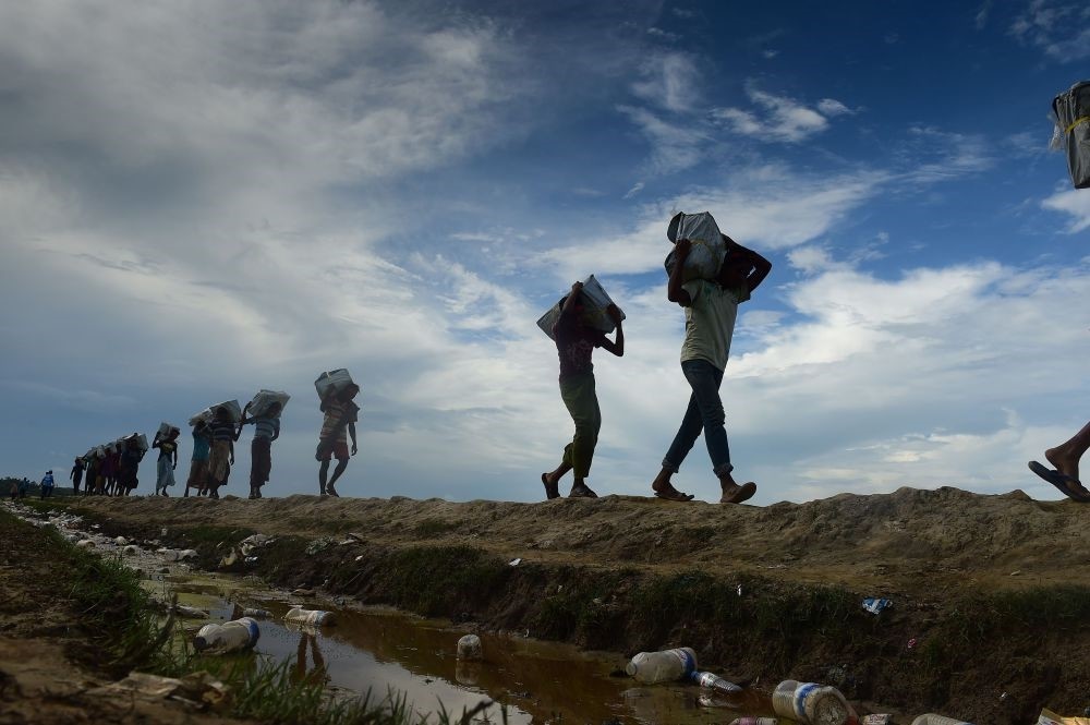 Bangladeshi workers carry relief supplies for Rohingya refugees in the Palongkhali area between Bangladesh and Myanmar, Oct. 18. 