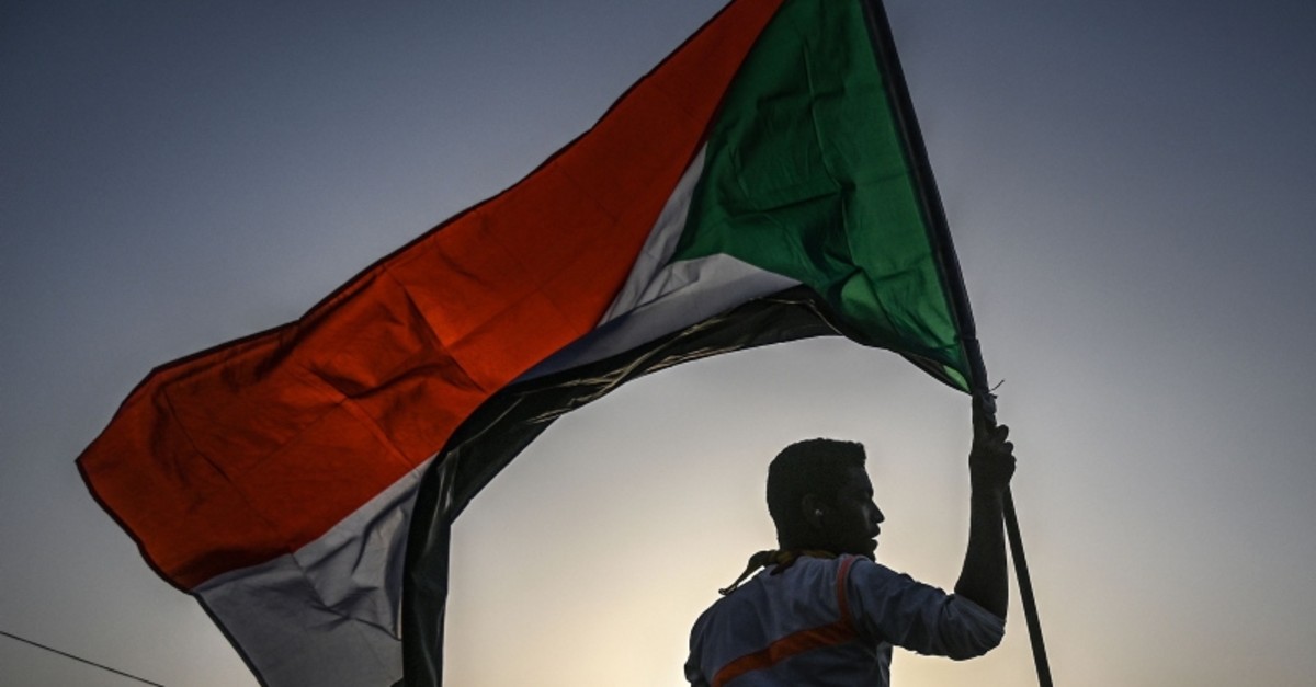 A Sudanese protester waves the national flag during a rally outside the army complex in Sudan's capital Khartoum on April 18, 2019. (AFP Photo)