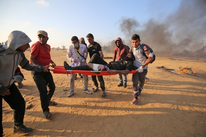 Palestinian medics carry on a stretcher a protester injured during clashes with Israeli forces along the border east of Khan Yunis in the southern Gaza Strip on May 15, 2018. (AFP Photo)
