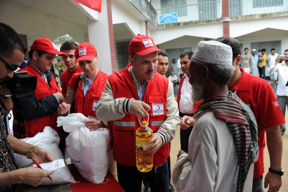 Members of the Turkish Red Crescent distribute aid to Rohingya Muslims living in a refugee camp in the Rakhine state. 