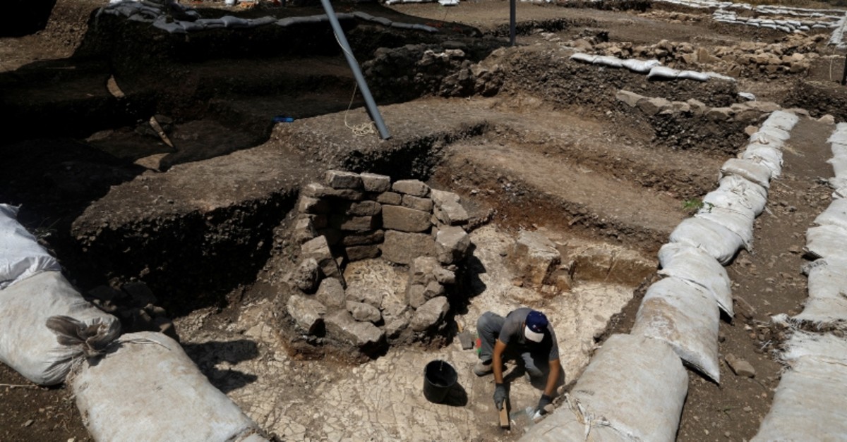 A man works next to a burial place at an excavation site where a huge prehistoric settlement was discovered by Israeli archaeologists in the town of Motza near Jerusalem (Reuters Photo)