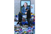 People look over flowers, tributes and messages of condolence outside the King Power stadium in Leicester, Oct. 29.