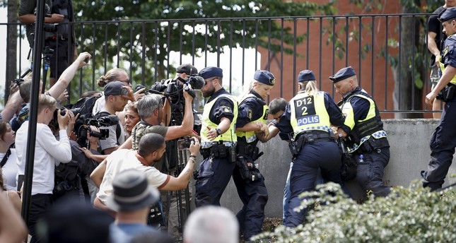 Police members try to restrain a man outside Stockholms mosque at Medborgarplatsen, Sweden, June 28, 2023. TT News Agency via AP