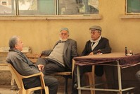 Producer and director Mehmet Tau015fdiken sitting with villagers.