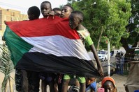 Young Sudanese boys carry a national flag as they celebrate the historic transitional constitution, Bahri, Aug. 18, 2019.