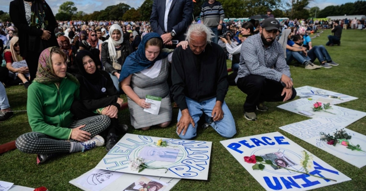Alaska Wood, 26, (centre L) comforts Mohammed Nadir, 58, (centre R) as he cries while taking part in a two minute silence for twin mosque massacre victims in a park near the Al Noor mosque in Christchurch on March 22, 2019. (AFP Photo)