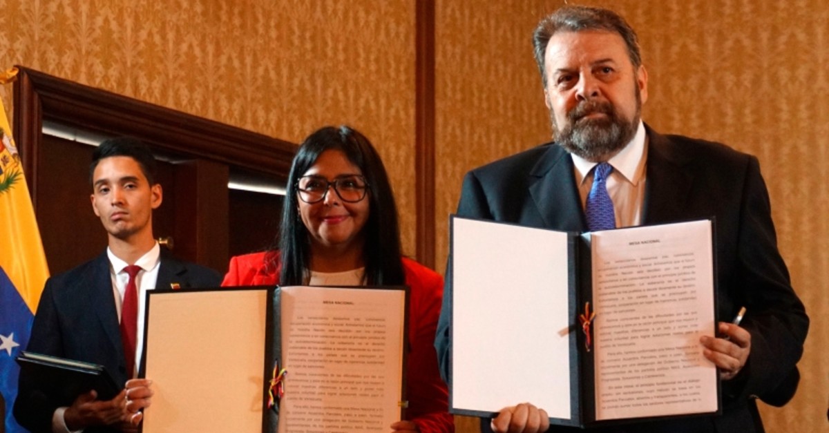 Handout picture from Venezuela's Foreign Ministry press office shows Vice-President Delcy Rodriguez (L) and opposition deputy Timoteo Zambrano (R) after signing an agreement for the government's return to Parliament, in Caracas, Sept. 16, 2019. (AFP)