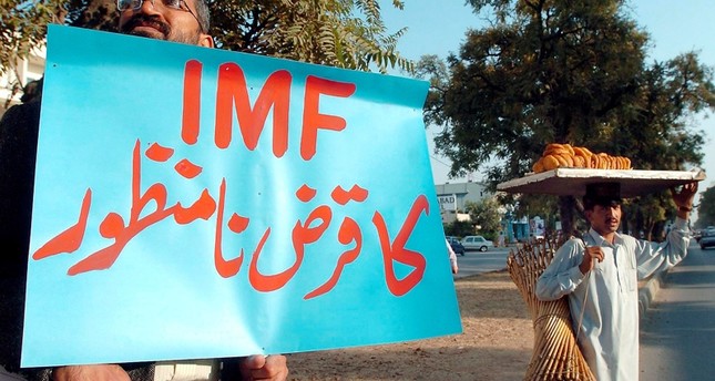 مواطن باكستاني يحمل لافتة مناهضة لصندوق النقد الدولي EPA