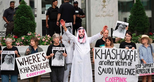People, including a demonstrator dressed as Crown Prince Mohammed bin Salman with blood on his hands, protest outside the Saudi Embassy in Washington, DC, Oct. 8, demanding justice for Jamal Khashoggi.