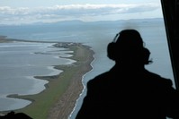  In this Aug. 7, 2008, file photo, Aviation Maintenance Tech 2, John Ferrari looks out of the back of a U.S. Coast Guard C-130 as he surveys the coast near the village of Kivalina, Alaska, during a surveillance flight to the Arctic (AP Photo)