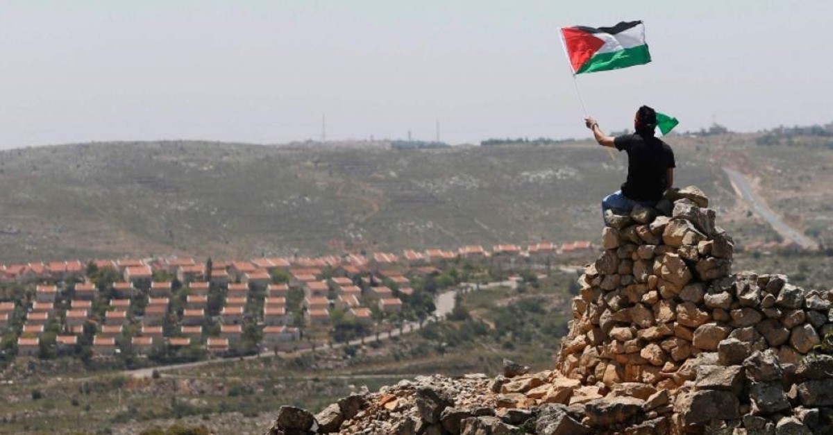A protester waves a Palestinian flag in front of the Jewish settlement of Ofra during clashes near the West Bank village of Deir Jarir near Ramallah April 26, 2013. (Reuters Photo)