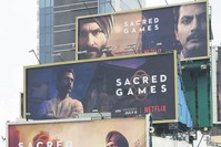 Indian commuters travel past large billboards for u2018Sacred Games,' the upcoming Indian series on Netflix, in Mumbai.