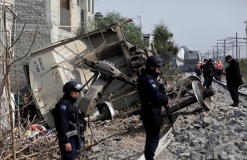 Federal police guard the site where the car of a cargo train ran off the tracks knocking a home in the municipality of Ecatepec, on the outskirts of Mexico City, Mexico. Jan. 18, 2018. (Reuters Photo)