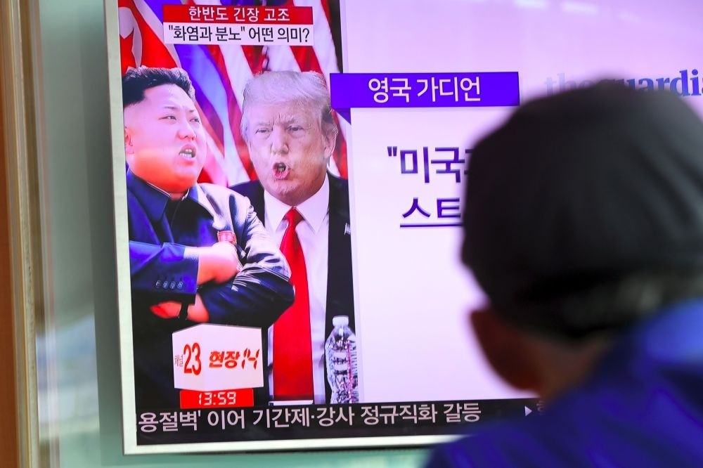 A man watches a television news program showing North Korean leader Kim Jong Un and U.S. President Donald Trump at a railway station in Seoul, Aug. 9, 2017. 