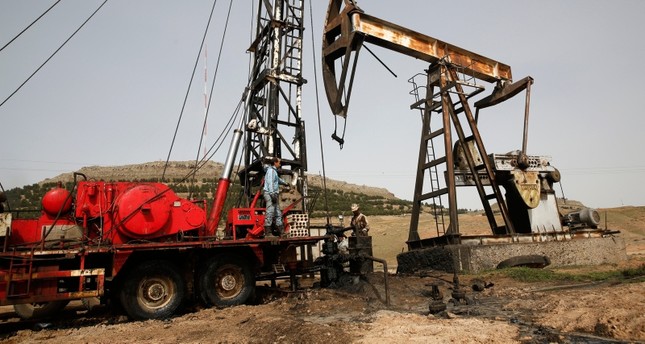 عمال يصلحون أحد أبار النفط في حقل الرميلان شرق سوريا AP