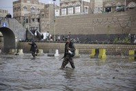 A Houthi militant guards a flooded street leading to a protest against the U.S. airstrike in Iraq that killed Iraqi militia commander Abu Mahdi al-Muhandis and Iranian Gen. Qassem Soleimani, in Sanaa, Yemen, Jan. 6, 2020. (AP Photo)