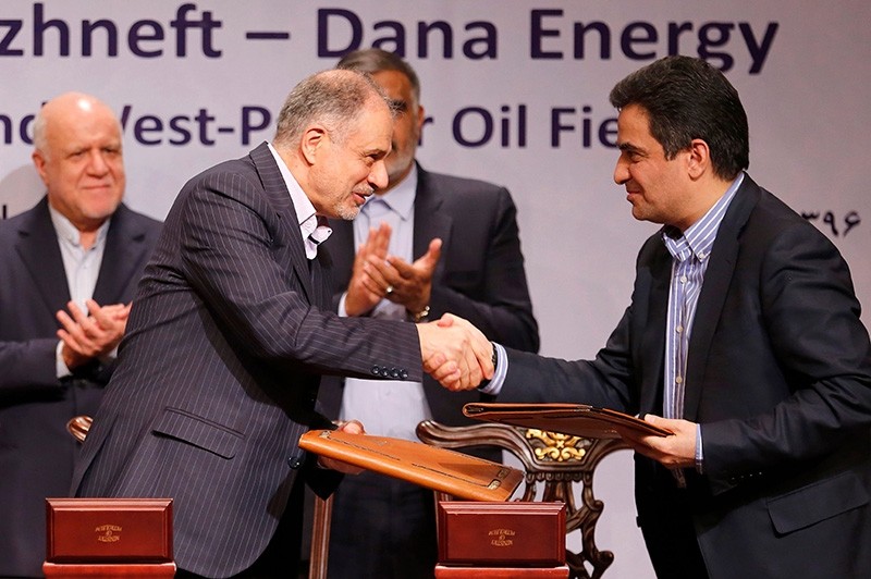 Ali Kardor Managing Director of Iran's National Oil Company (L) shakes hands with Mohammad Iravani CEO and Chairman of Dana energy after sign an oil field agreement in Tehran, on March 14, 2018. (AFP Photo)