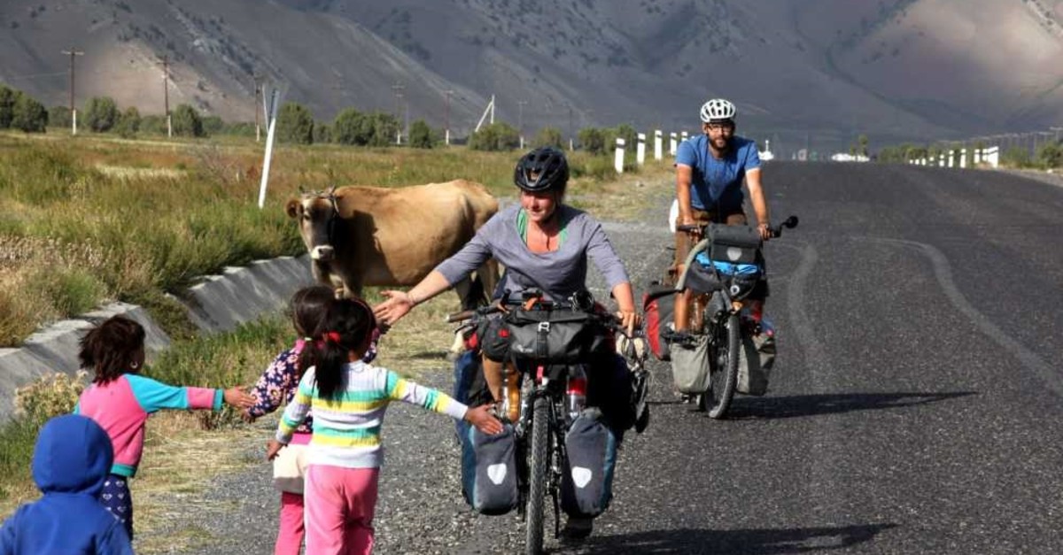 Cyclists Christian Pries (R) and Maren Hagel are greeted by the local children during their journey through Turkey.