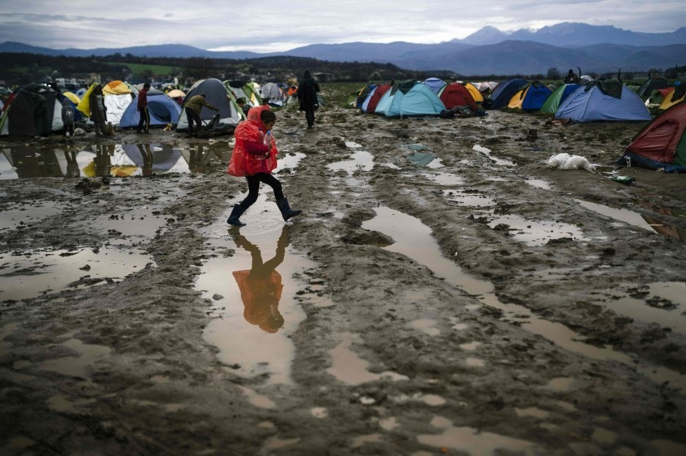 A girl walks in the mud in a makeshift camp at the Greek-Macedonian border, near the Greek village of Idomeni, March 9, 2016. 