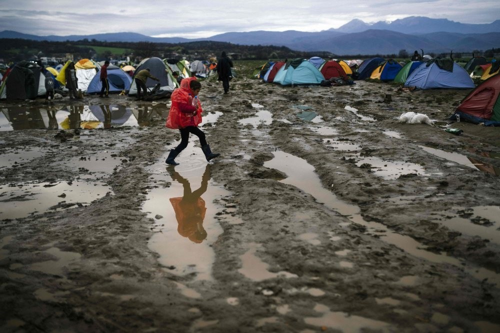 A girl walks in the mud in a makeshift camp at the Greek-Macedonian border, near the Greek village of Idomeni, March 9, 2016. 