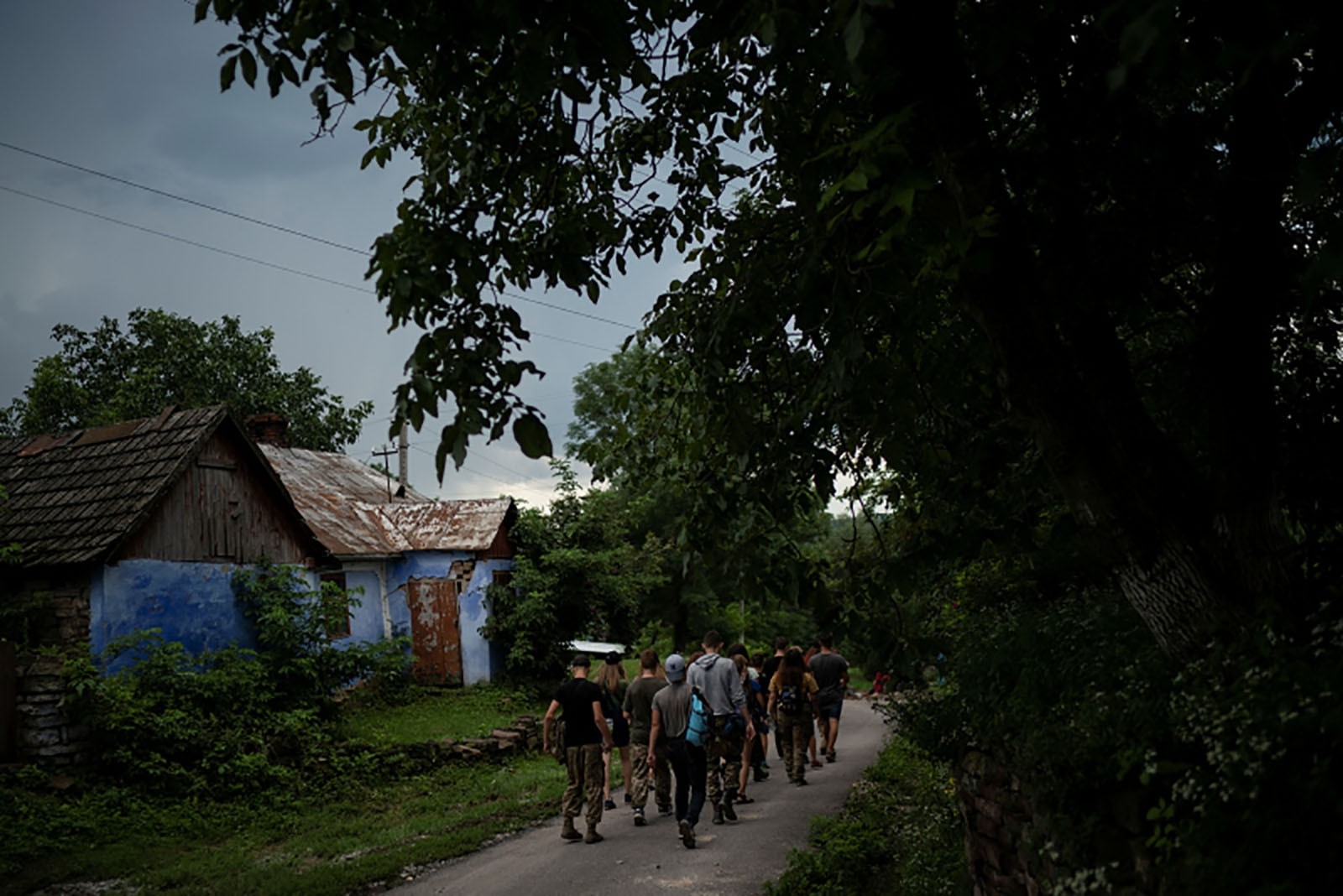 Young participants of the camp walk to a campsite in a village.