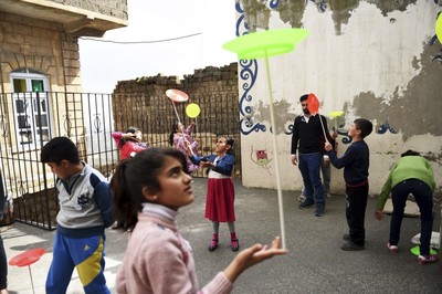 Syrian children perfom during a circus class on the roof top of a building.