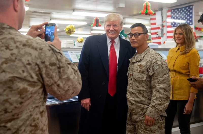 President Donald Trump poses for a picture with Lieutenant Commander Kyu Lee, the chaplain for SEAL Team Five, a U.S. Navy special operations unit based out of Coronado, Al Asad Air Base in Iraq on December 26, 2018. (AFP Photo)
