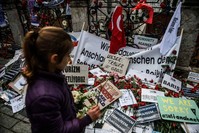 A child stands in front of a makeshift memorial with flowers and candles in tribute to victims at the site of the Jan. 12 deadly terrorist attack in Istanbul's tourist hub of Sultanahmet, Jan. 14, 2016.