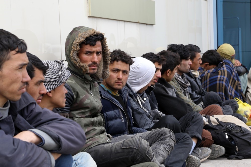 Migrants, including Afghans and Pakistanis, wait outside a police station after they were intercepted in Erzurum, April 3.
