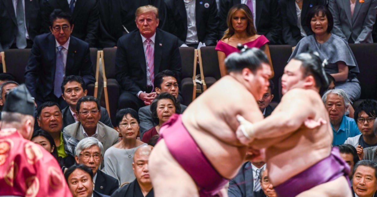 U.S. President Donald Trump accompanied by Japan's Prime Minister Shinzo Abe as they watch a sumo battle during the Summer Grand Sumo Tournament in Tokyo on May 26, 2019. (AFP Photo)