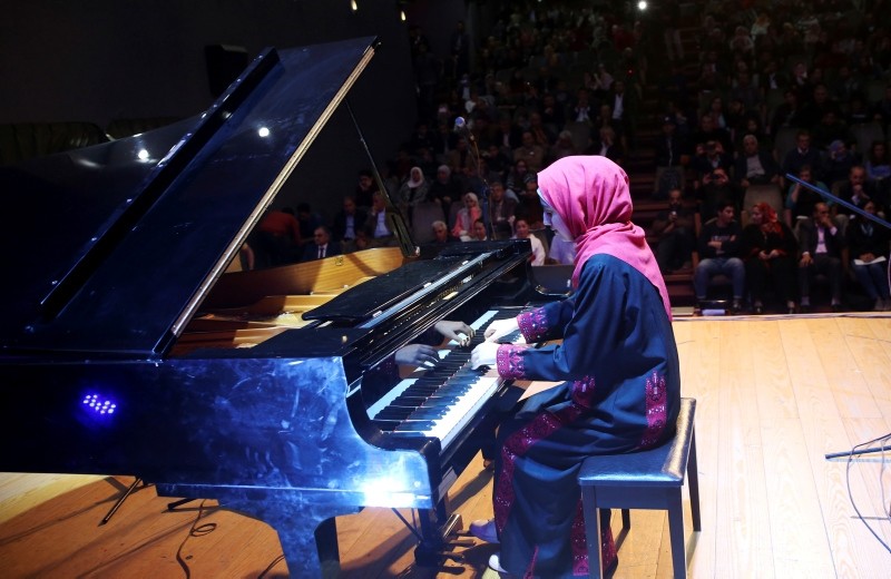 Palestinian pianist Yara Thabit plays the piano during a concert to mark the debut of Gaza's only grand piano after it was rescued from conflict, at a theater in Gaza City, Sunday, Nov. 25, 2018. (AP Photo)