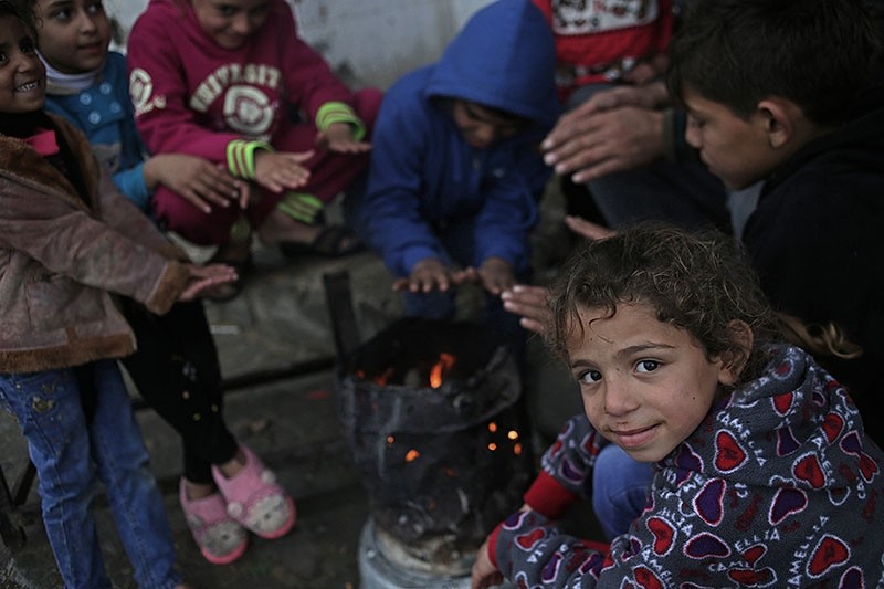 Palestinian children's warm themselves by fire outside their house in the street of Beit Hanun town northern Gaza Strip, during stormy weather in Gaza Strip, Jan. 27, 2018. (EPA Photo)