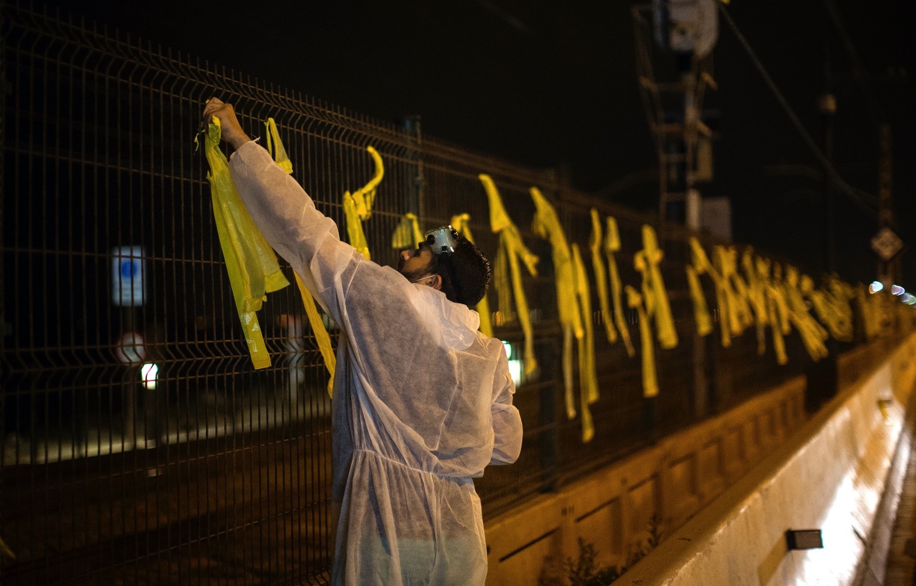 A man removes yellow  ribbons placed on a fence by Catalan separatists, Premia del Mar, Sept. 4.