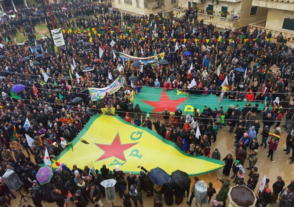 YPG supporters wave giant flags during a protest against Turkey's counterterrorism operation into Afrin to eliminate YPG terrorist elements near its borders to protect the safety of both its own people and Syrians, Syria, Jan. 18. 