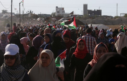 Palestinian women march while waving their national flags toward the Gaza Strip's border with Israel, during a protest east of Gaza City, July 3, 2018. (AP Photo)