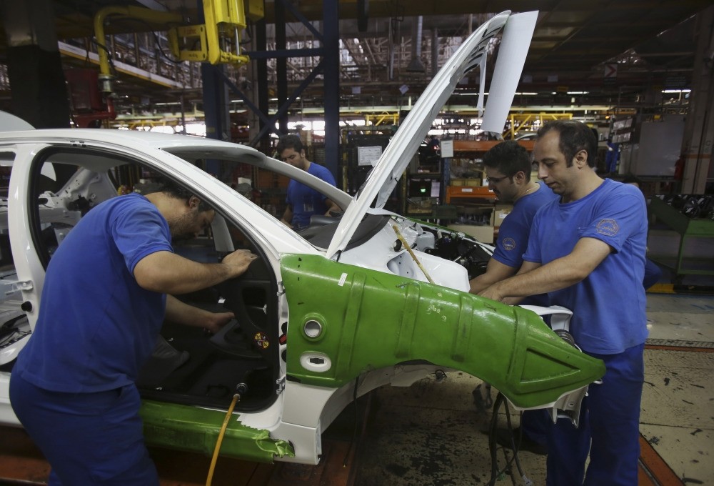 Iranian car workers assemble a car at the state-run Iran-Khodro automobile manufacturing plant near Tehran, Iran.