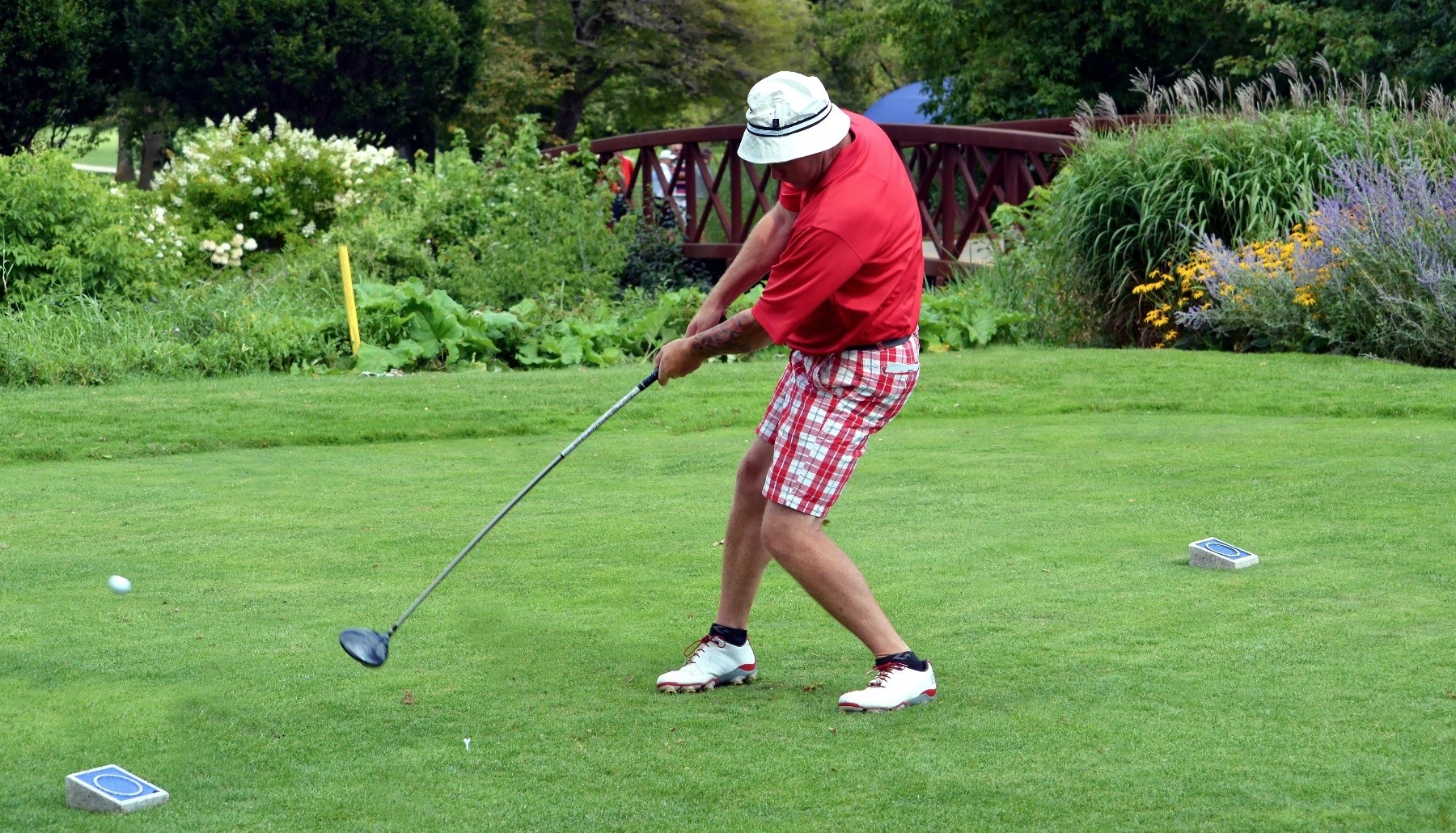 A left-handed golfer hits the ball during a tournament.