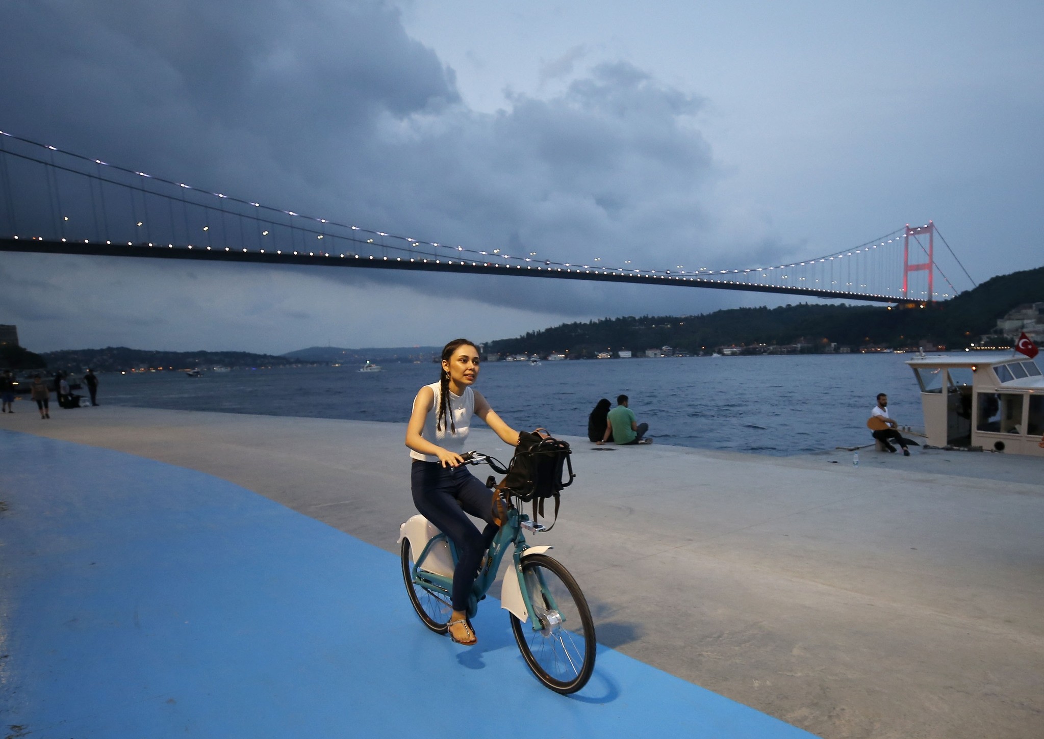A woman rides near Istanbulu2019s water front with the bike she rented from u0130SBIKE.