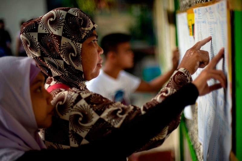 Muslim women look for their names at a voting precinct in Maguindanao, on the southern island of Mindanao on January 21, 2019 (AFP Photo)